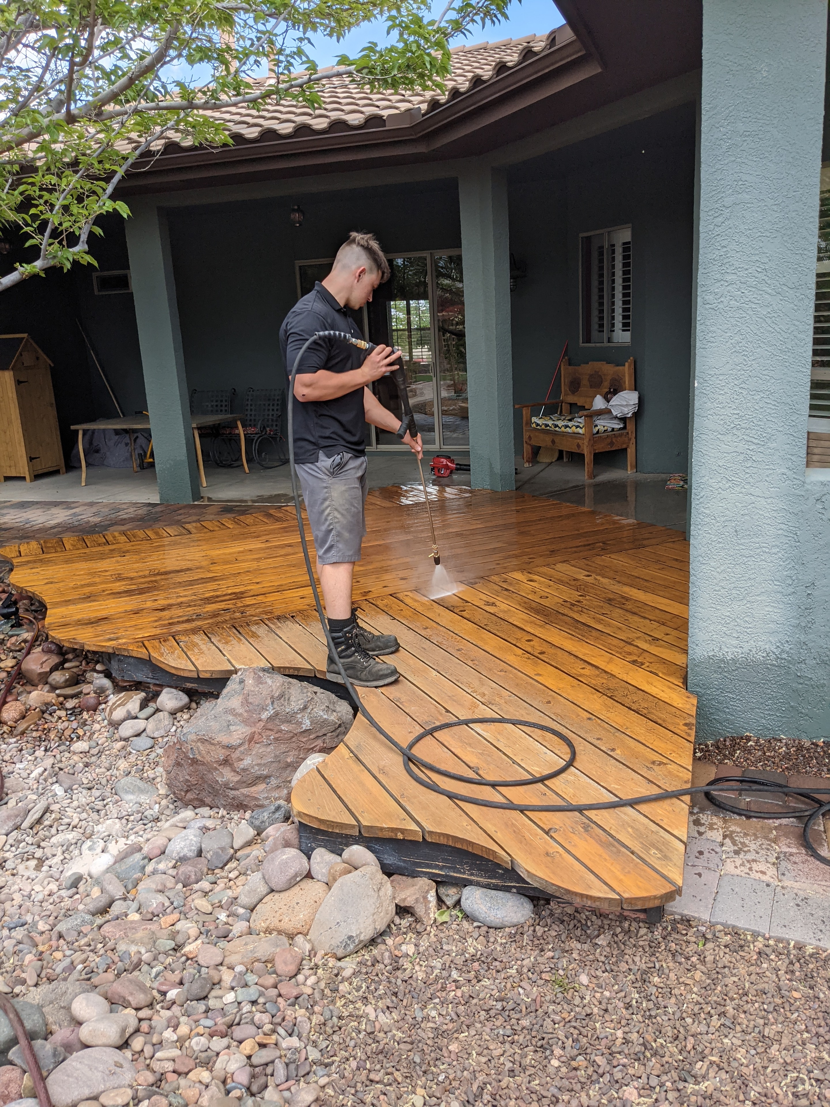 Demigod technician pressure washing a wood deck at a Cottonwood, AZ residential property