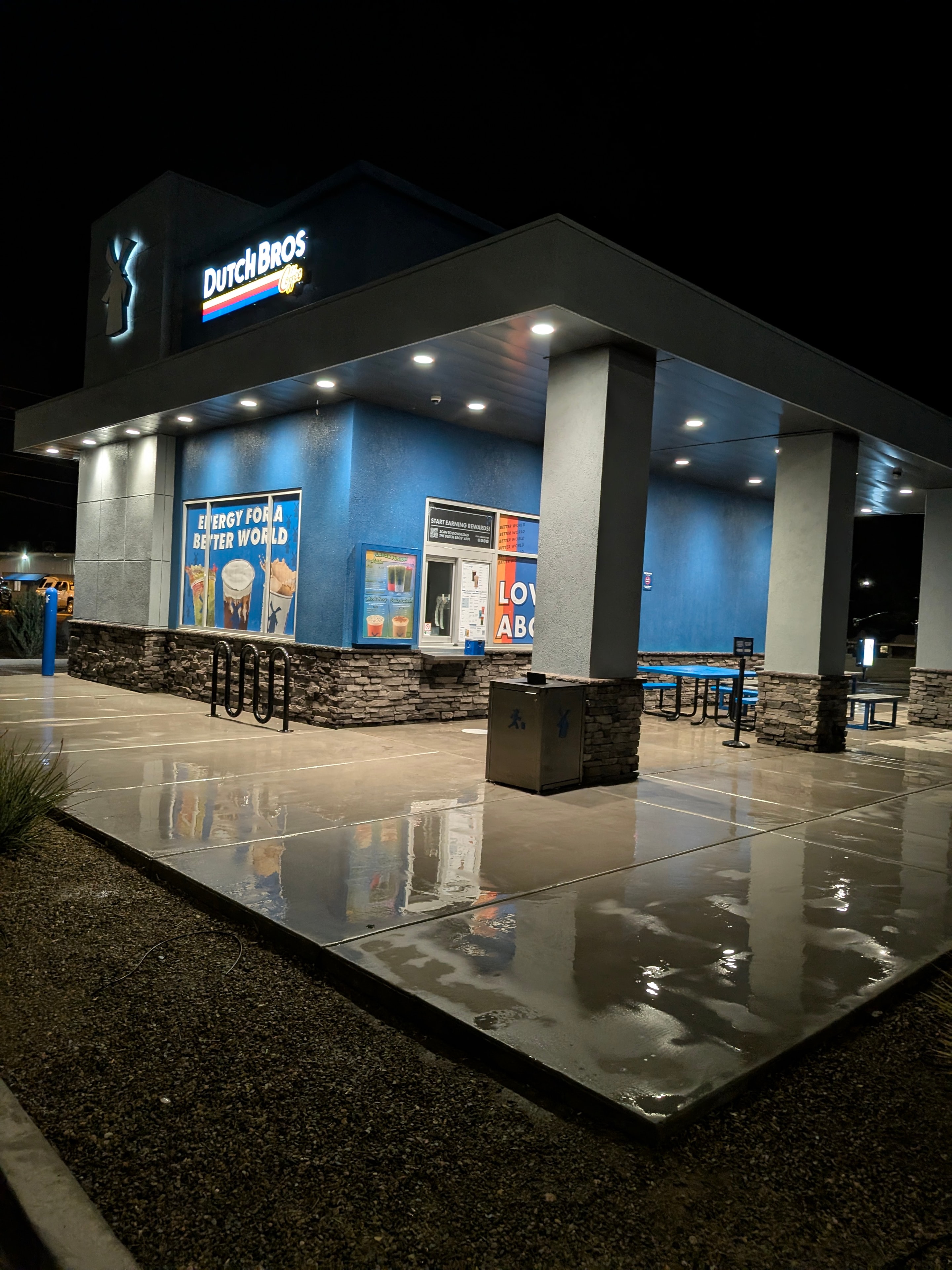 Pressure washed concrete at Dutch Bros Coffee in Cottonwood, AZ — gleaming clean commercial exterior at night