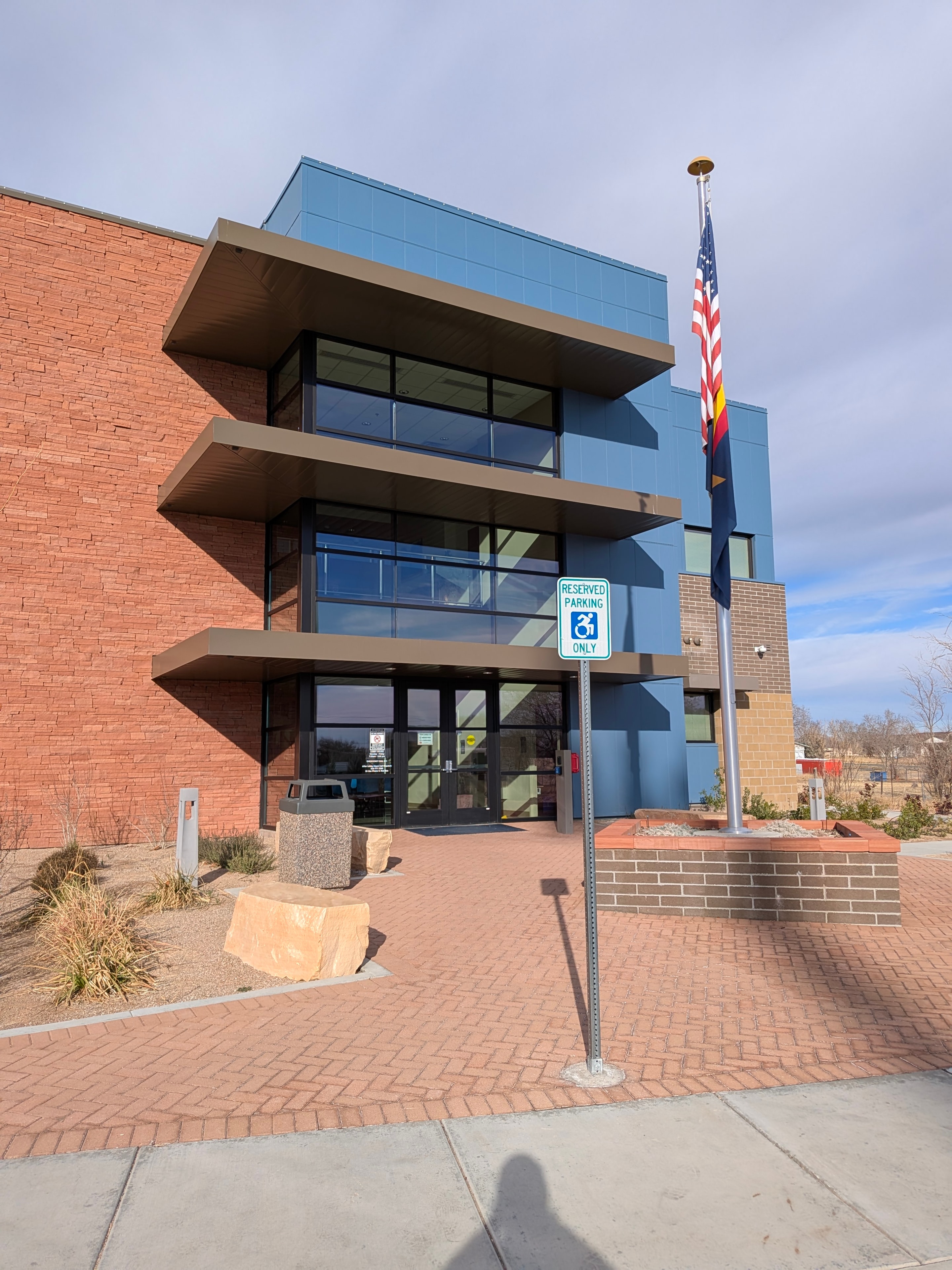Multi-story commercial building with floor-to-ceiling windows cleaned by Demigod in Prescott, AZ with American flag