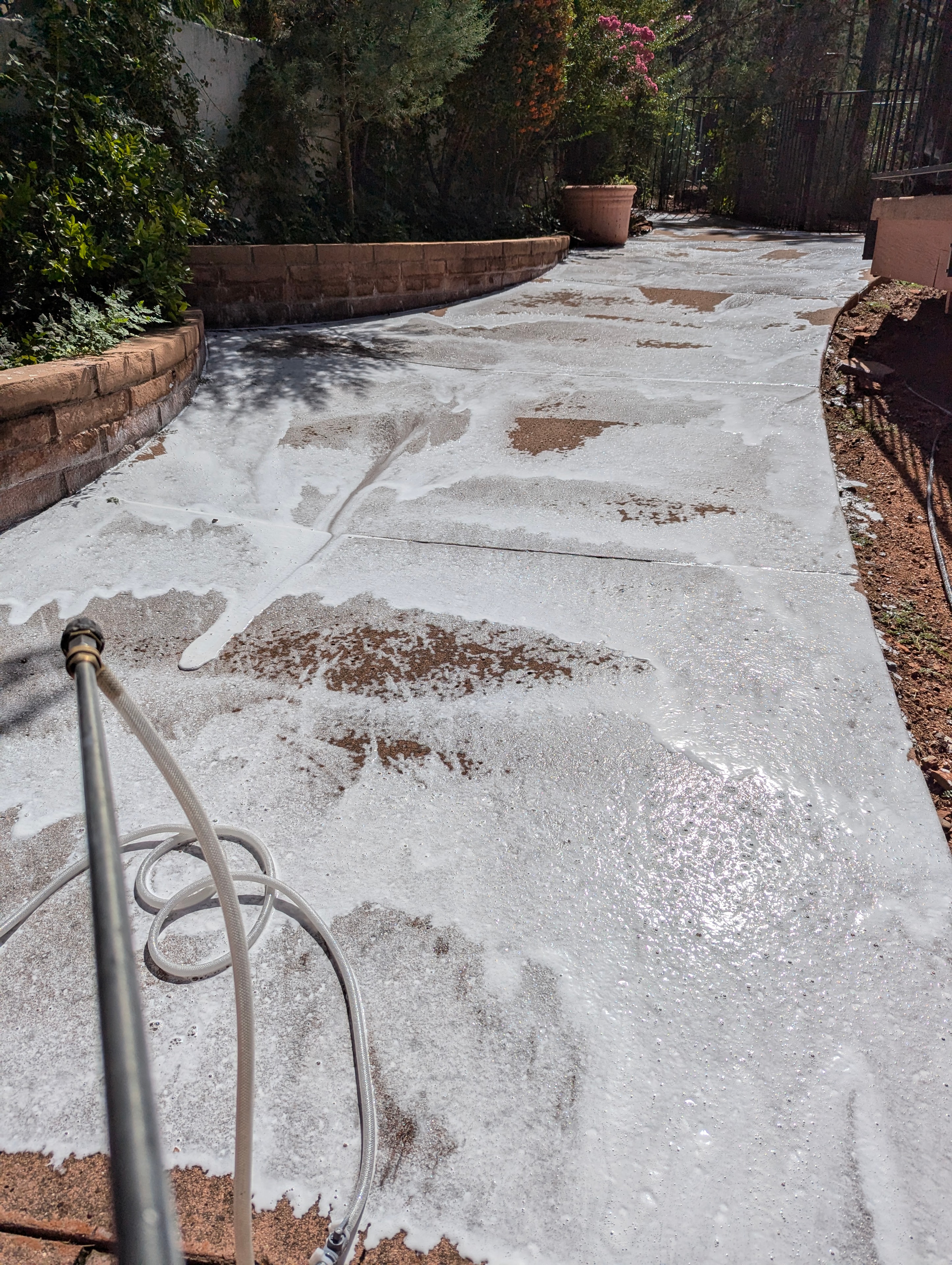 Pressure washing a concrete patio and driveway in Sedona, Arizona — foam cleaning treatment removing desert grime